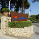 Eingangsschild des Club Santa Ponsa auf Mallorca mit Steinmauer und Bepflanzung