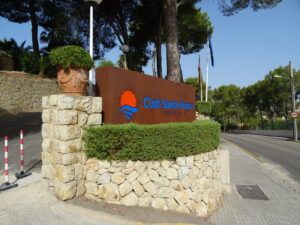 Eingangsschild des Club Santa Ponsa auf Mallorca mit Steinmauer und Bepflanzung