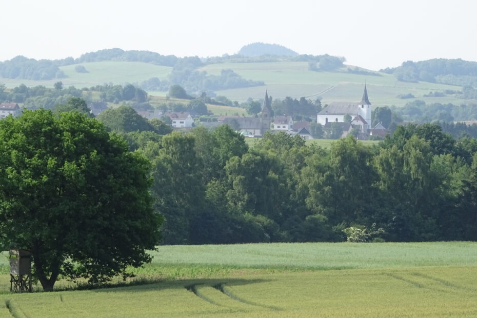 Bärenbachpfad - Dorf mit Kirche in hügeliger Sommerlandschaft