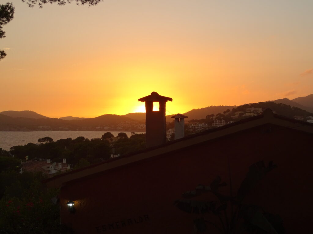 Sonnenuntergang über Santa Ponsa mit Silhouetten der Hügel und Dächer