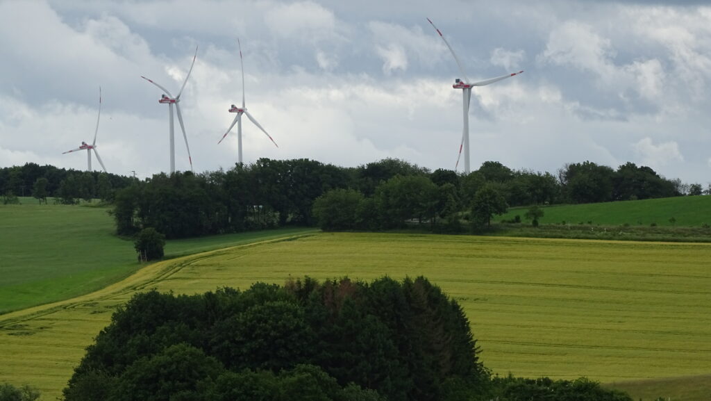 Windräder auf Feldern und Wiesen bei Breitenbach, unter dramatischem Himmel mit dunklen Wolken