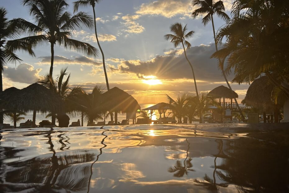 Sonnenuntergang am Infinity-Pool des Hilton La Romana – Blick aufs Meer mit Palmen und Strohdächern