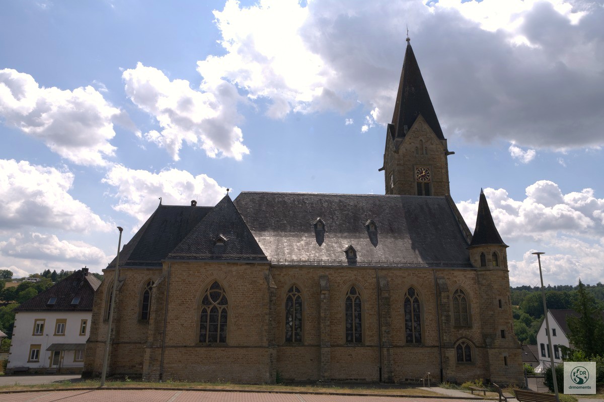 Neugotische Sandsteinkirche mit Uhrturm im Ortskern am Wortsegel-Wanderweg